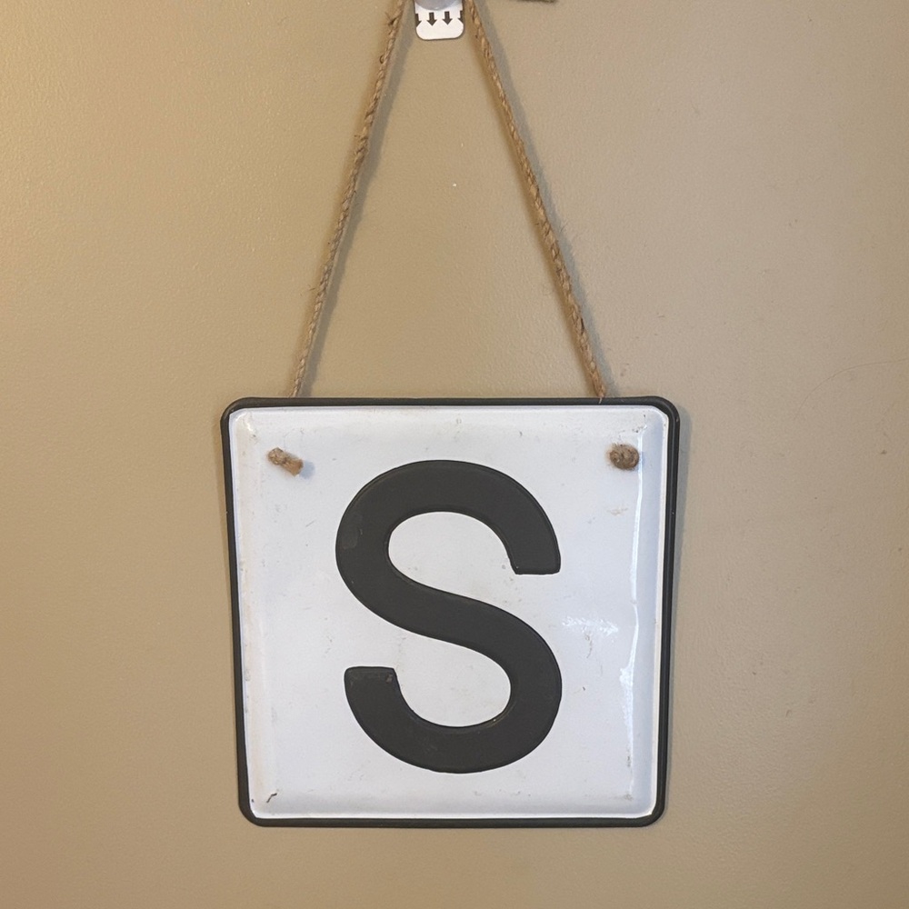 White Hanging Sign with Black Letter 'S'